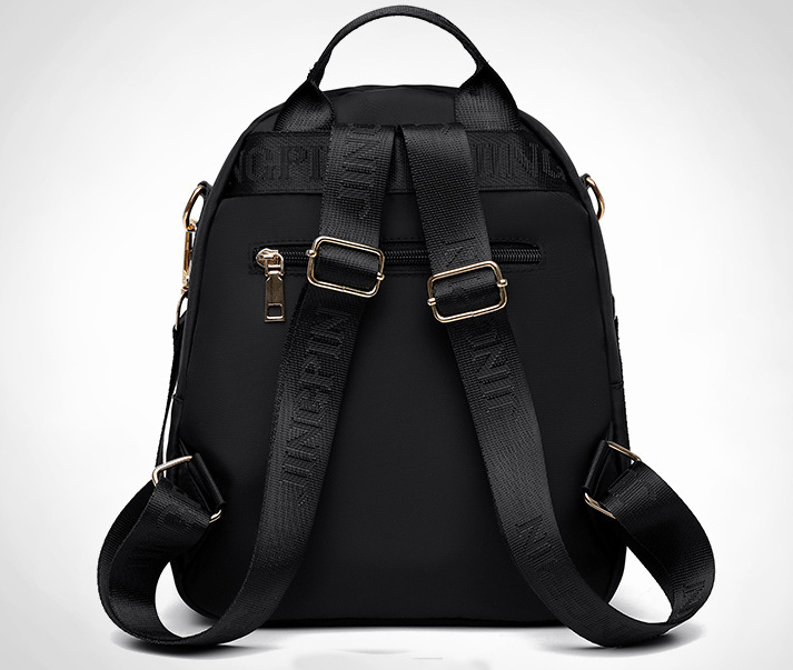 Back view of a black SKUGG women’s mini backpack with adjustable shoulder straps, premium zipper pocket, and stylish compact design on a clean background.